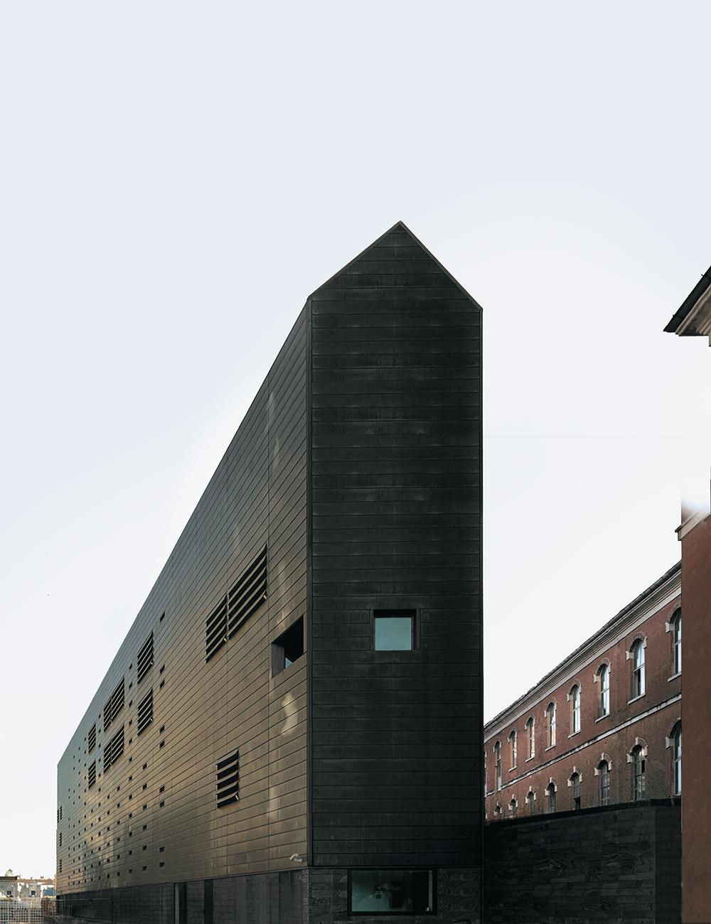 Venedigs neuer Stadteingang von C + S Architects zur Piazza de Roma erinnert an die metaphysischen Szenen von Giorgio de Chirico: Das in voroxidiertes Kupfer gehüllte Eingangsgebäude zum ziegelfarbenen Gerichtskomplex steht im Kontrast zum benachbarten weiß gebänderten Parkhaus.