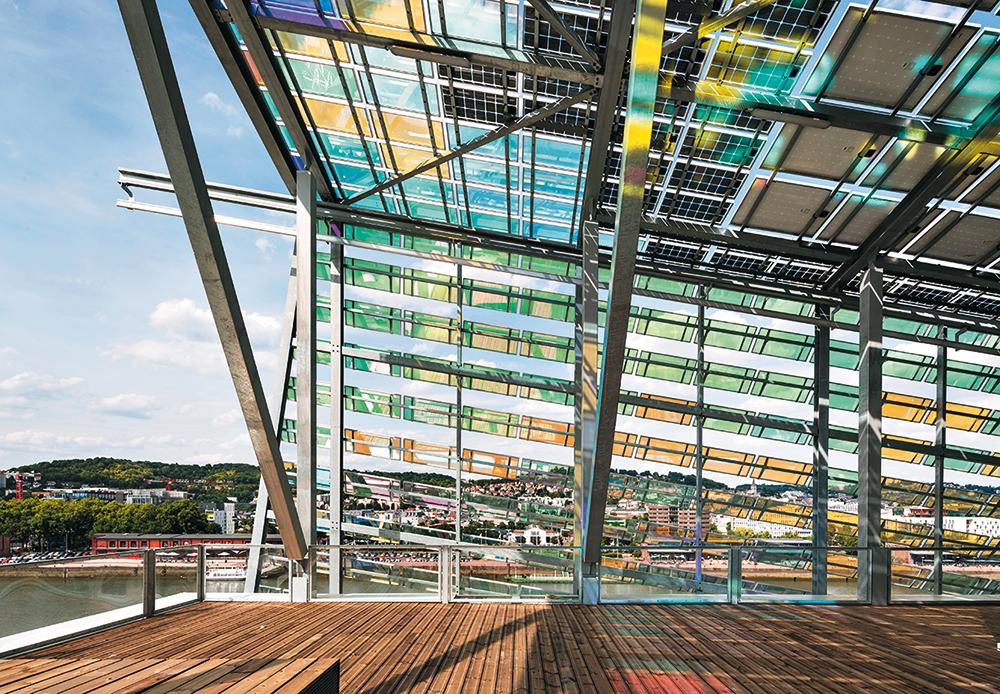 Unter den farbigen Gläsern der Dachhaut verbinden sich die Dachterrassen visuell mit den von oben belichteten Innenhöfen zu attraktiven Kommunikationsräumen im Freien.