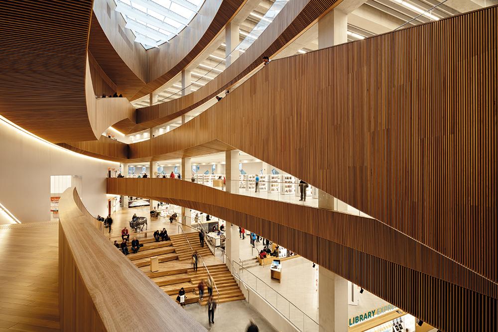 Die Stadtbahntrasse und ein öffentlicher Platz durchkreuzen die neue Bibliothek auf unterschiedlichen Ebenen. Im Inneren setzt sich die Plaza als Atrium fort.