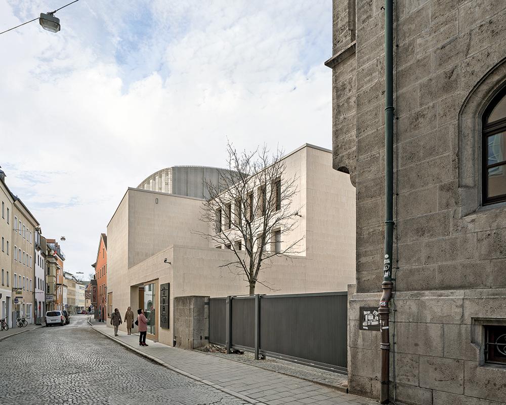 Mit dem Neubau wird das bis 1938 bestehende sakrale Dreieck aus protestantischer Neupfarrkirche, katholischem Dom und jüdischer Synagoge wieder hergestellt.