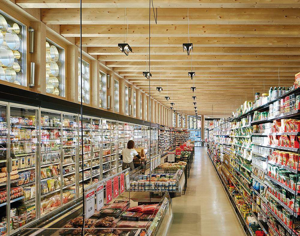 Beim Supermarkt in Piesendorf von Fügenschuh Hrdlovics Architekten sind vorgehängte Messing-zylinder Blickfang und Brise Soleil in einem.