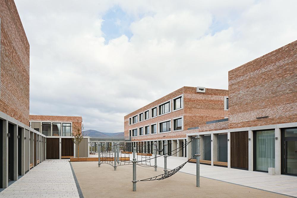 Der Hof der Grundschule bildet die Mitte des Gebäudekomplexes. Für den Kindergarten ist seitlich davon ein privaterer Bereich abgetrennt.