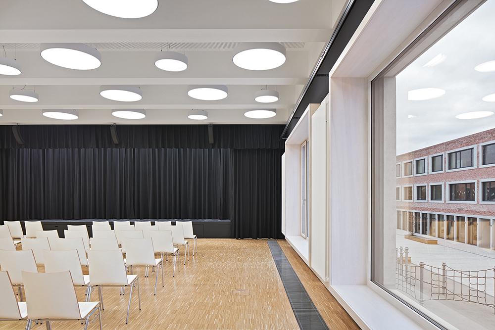 Mit fast bodentiefen Fenstern öffnet sich der Mehrzwecksaal zum Hof.