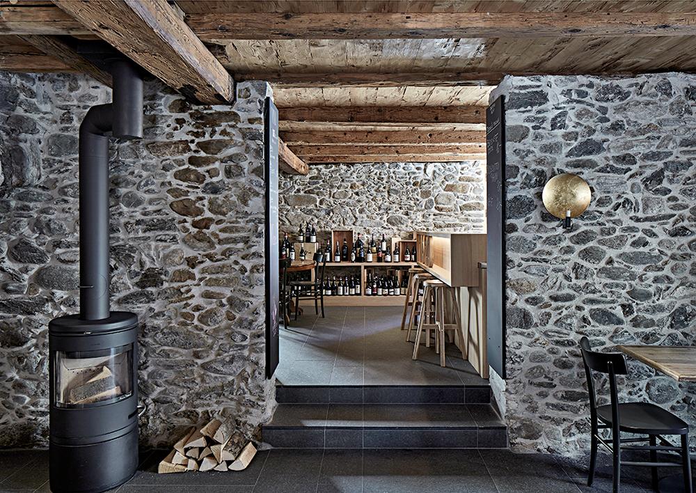 In der Weinbar im Sockelgeschoss legten die Architekten das Bruchsteinmauerwerk offen und verwendeten die alten Lärchenholzdielen als Deckenverkleidung wieder.
