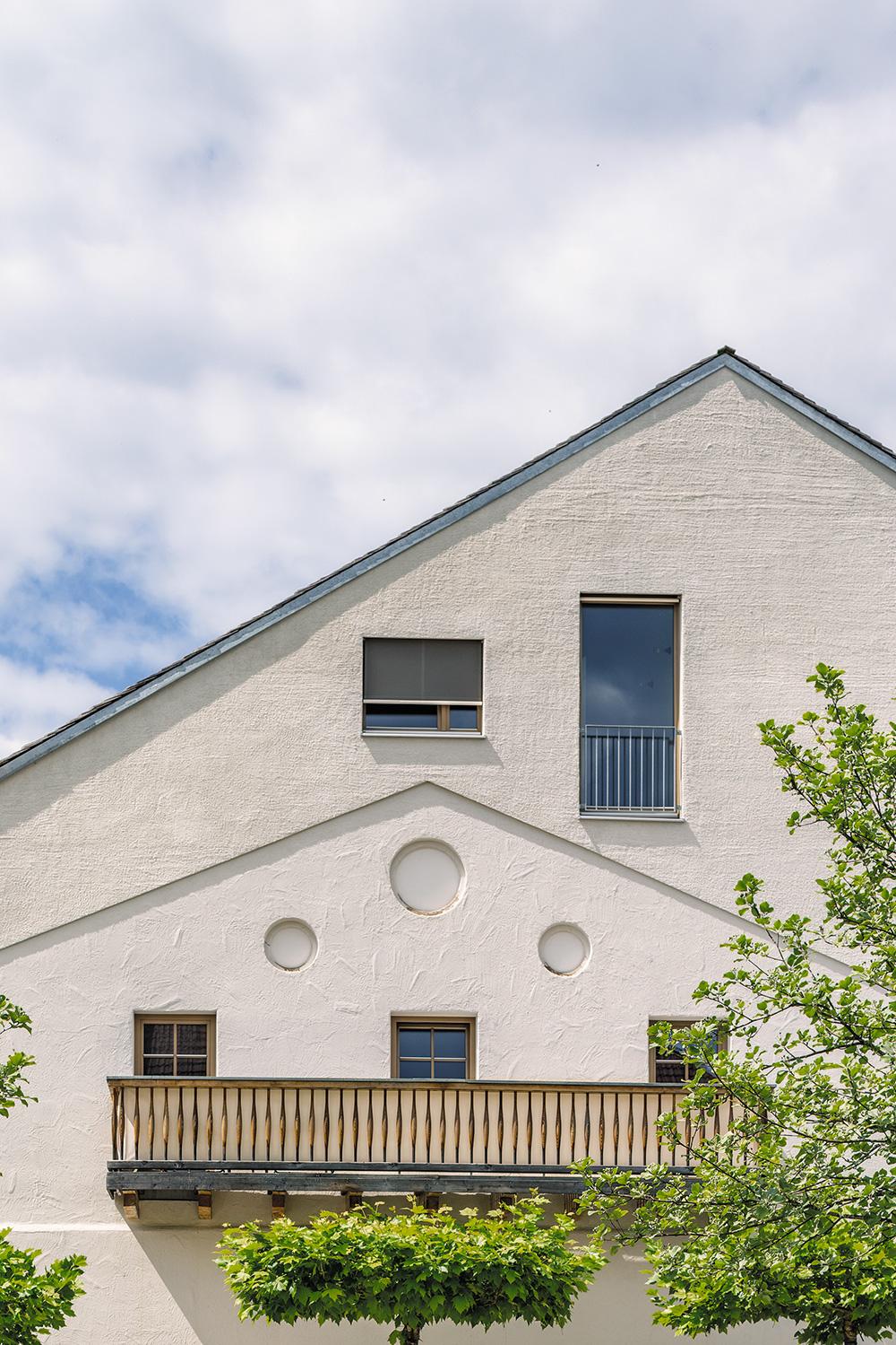 Wie einen Stempelabdruck haben Kehrbaum Architekten die Fassade eines abgetragenen Bauernhauses in der Giebelwand sichtbar gemacht und durch unterschiedliche Putzoberflächen, Brüstungen und Fensterteilungen zusätzlich hervorgehoben.