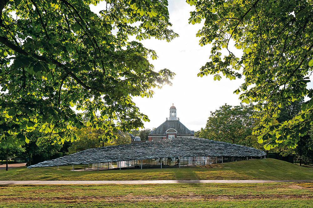 Wie ein fliegender Teppich wächst der diesjährige Serpentine-Pavillon mit seinem Schieferdach aus der Wiese und schwebt über dem Boden.