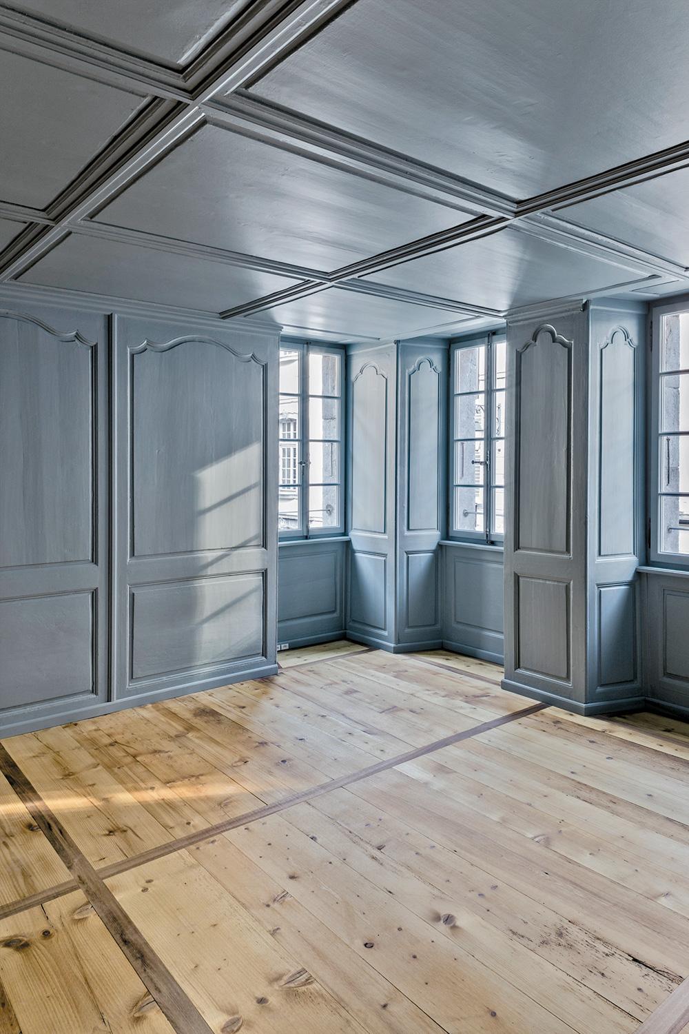Im Eingangsbereich zu den Werkstätten erinnert ein Fenster daran, wo das Haus früher endete. Heute schafft es den Sichtbezug zur Galerie Oblique im Erdgeschoss. Hinter den pastellfarbenen Türen ist die Garderobe untergebracht.