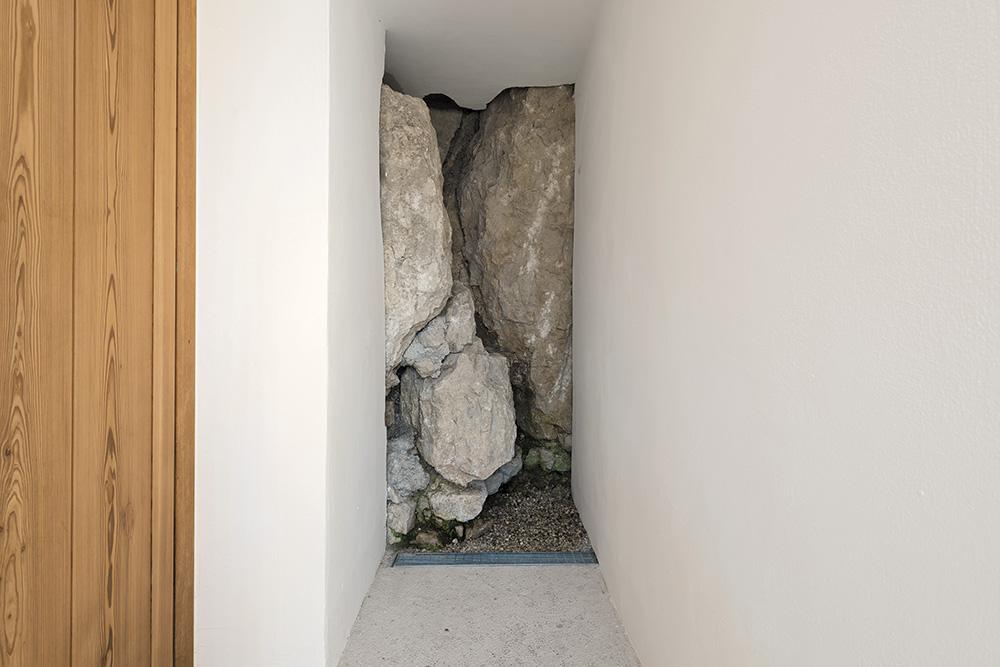 In der untersten Ebene ragt der rohe Fels blank in den Raum. Eine Dränrinne führt das Hangwasser ab.