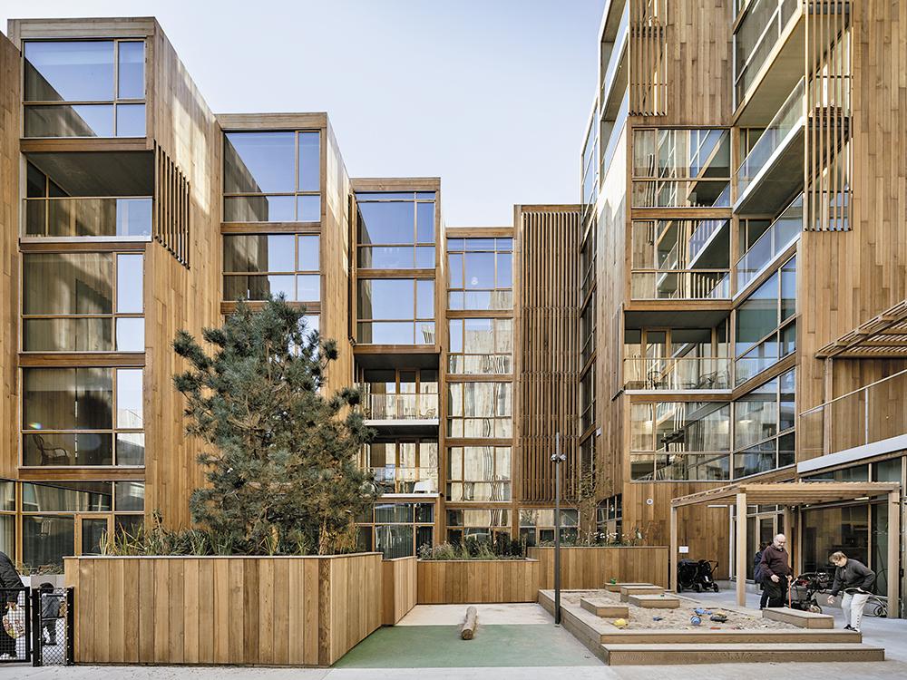 Ein Wohnblock mit zwei Gesichtern: Nach Norden und zu den seitlichen Nachbarn schotten sich die Wohnungen mit Holzfassaden ab, nach Süden zum Park sind sie verglast.