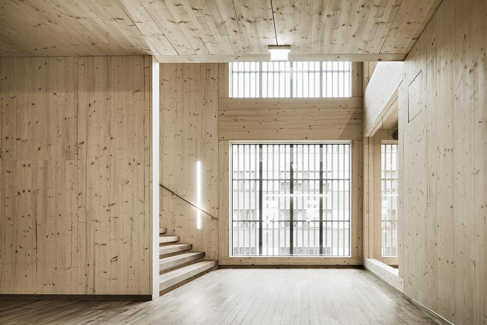 Obwohl die zentrale, offene Treppe auch Fluchtweg ist, konnte sie in Holz ausgeführt werden. Die hohe Festigkeit von Furnierschichtholz aus Buche machte dies möglich.