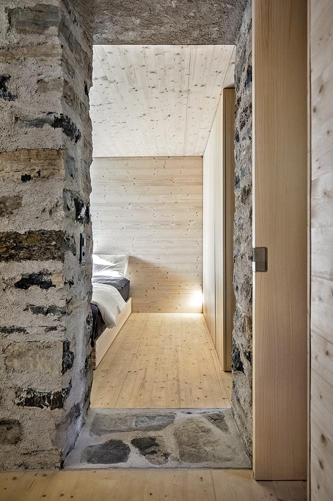 In den Schlafräumen der Bauherrn im Obergeschoss treffen die alten Mauern unmittelbar auf den gedämmten Innenausbau. Andernorts inszenieren Glasflächen den Altbau wie Schaufenster.