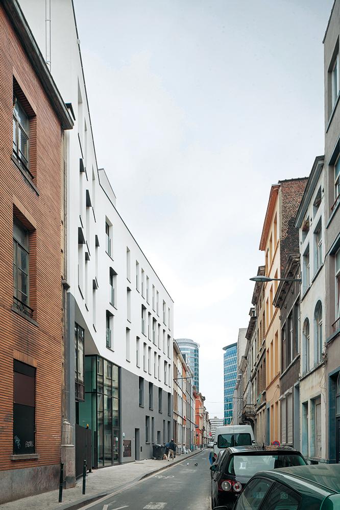 Der fünfgeschossige Apartmentblock wurde Richtung Westen verbreitert. Der Knick in seiner neuen Fassade markiert den Durchgang zum Innenhof.