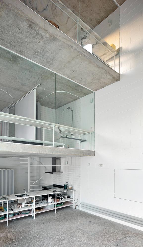 In front of the panes of glass drawn across each floor is a long, white marble table strip. Other materials were kept strikingly simple: ground concrete surfaces, painted brickwork and steel, plus tiles and glass.