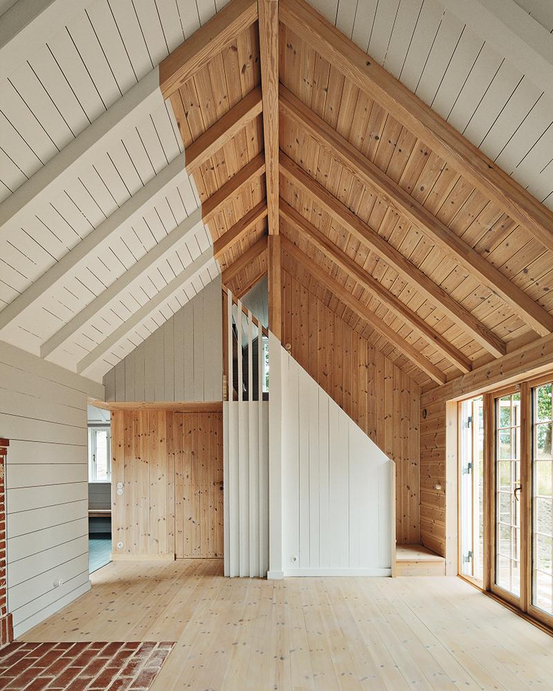 Eine leichte Dachkonstruktion mit Holzfaserdämmplatten liegt auf den sichtbaren Sparren auf.