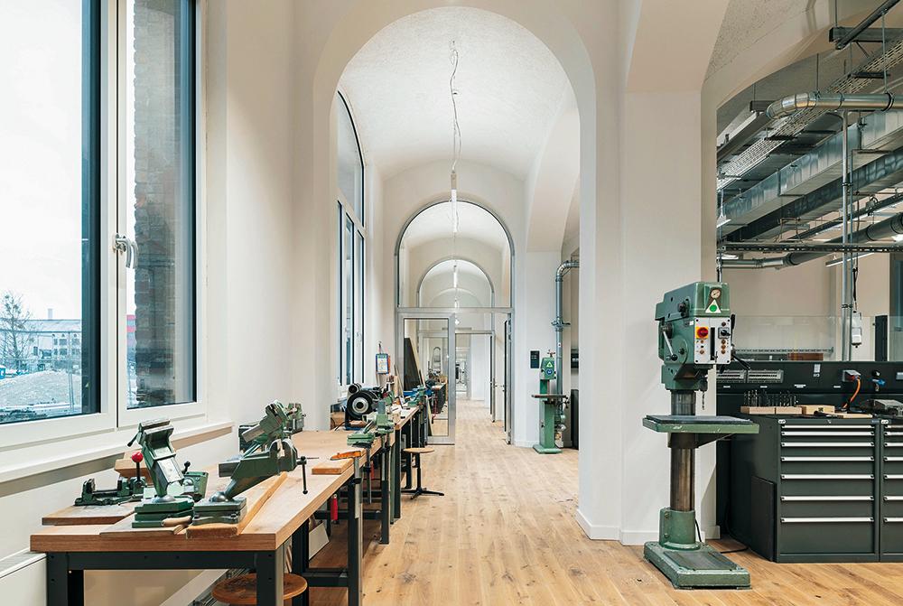 Der Bestandsbau blieb in seinen Grundzügen erhalten. Als sichtbar neues Element ziehen sich mit gebürstetem Aluminium verkleidete Brüstungen durch das gesamte Gebäude.