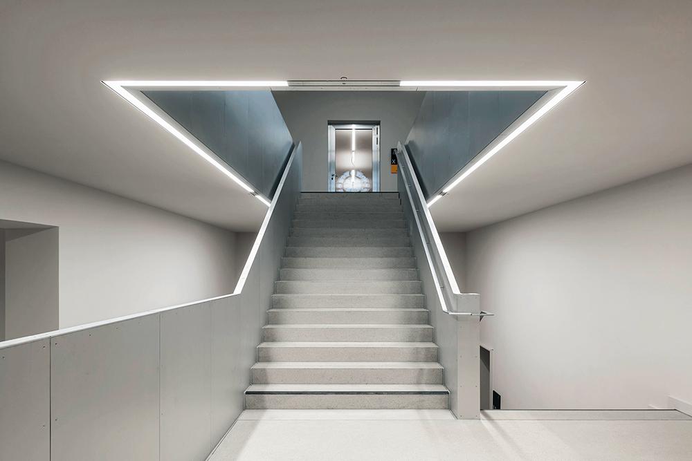 Der Bestandsbau blieb in seinen Grundzügen erhalten. Als sichtbar neues Element ziehen sich mit gebürstetem Aluminium verkleidete Brüstungen durch das gesamte Gebäude.