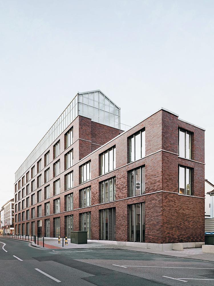 Mit seiner dunklen Ziegelfassade greift der Neubau eine Bautradition des Ruhrgebiets auf. Die gläserne Dachkrone ist in ihrem Umfeld jedoch einzigartig.