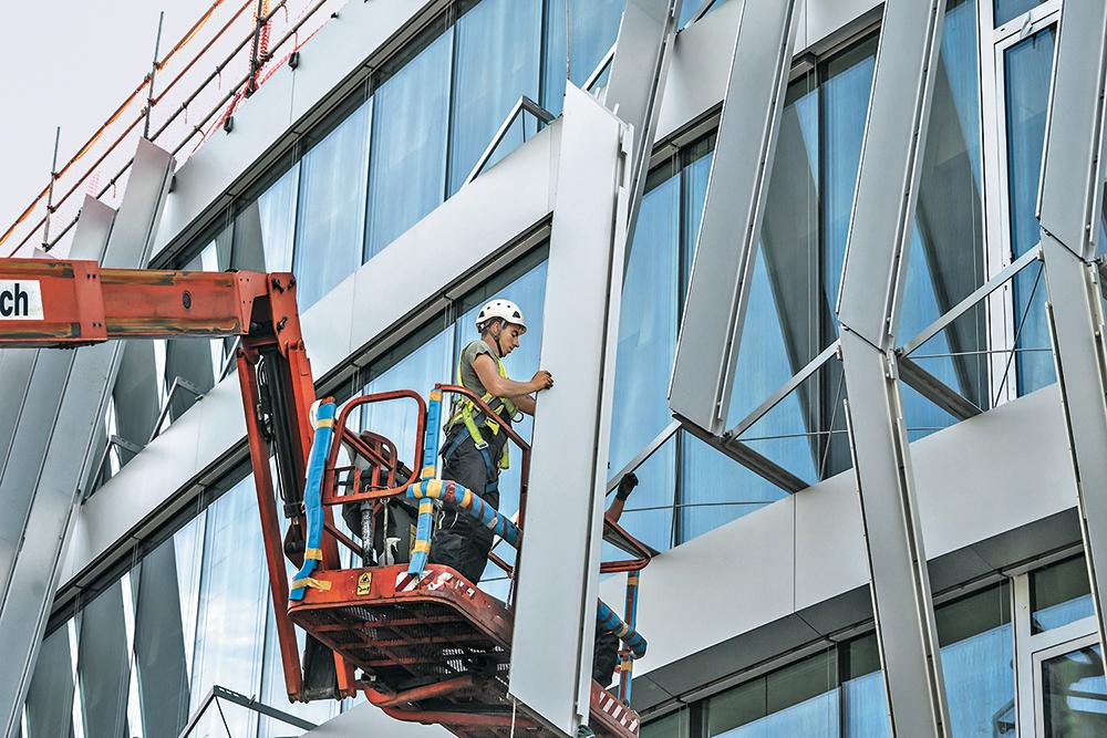 Äußere Fassade: Die Schwerter der oberen zwei Geschosse sind vom Dach abgehängt. Im 1. OG sind die Schwerter auf die Erdgeschossdecke aufgestellt.
