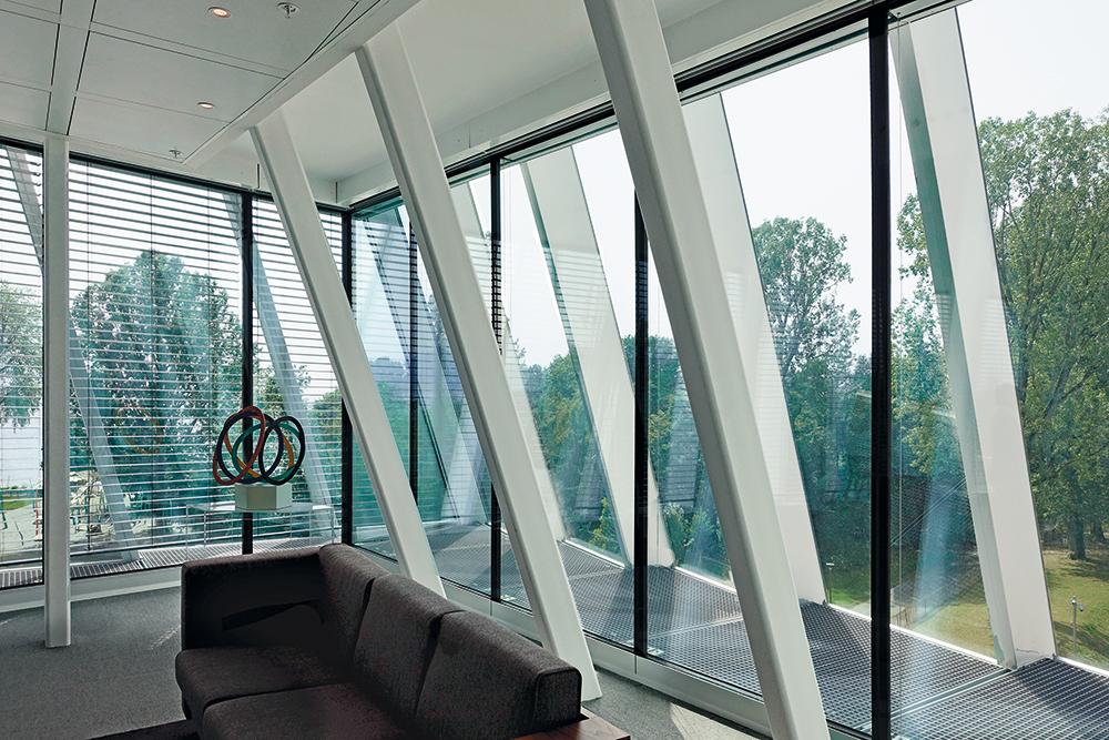 Die gefächerte Gebäudehülle aus Tragwerk und Fassade ist hochtransparent und macht die Dynamik der äußeren Form auch an den Arbeitsplätzen erlebbar.