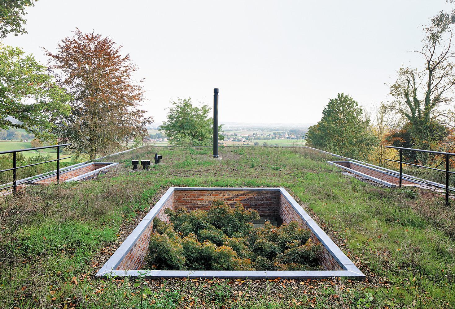 Zu den Eingängen des Hauses, das zur Hälfte in der Erde steckt, gelangt man über das Dach und zwei hinabführende Treppen.