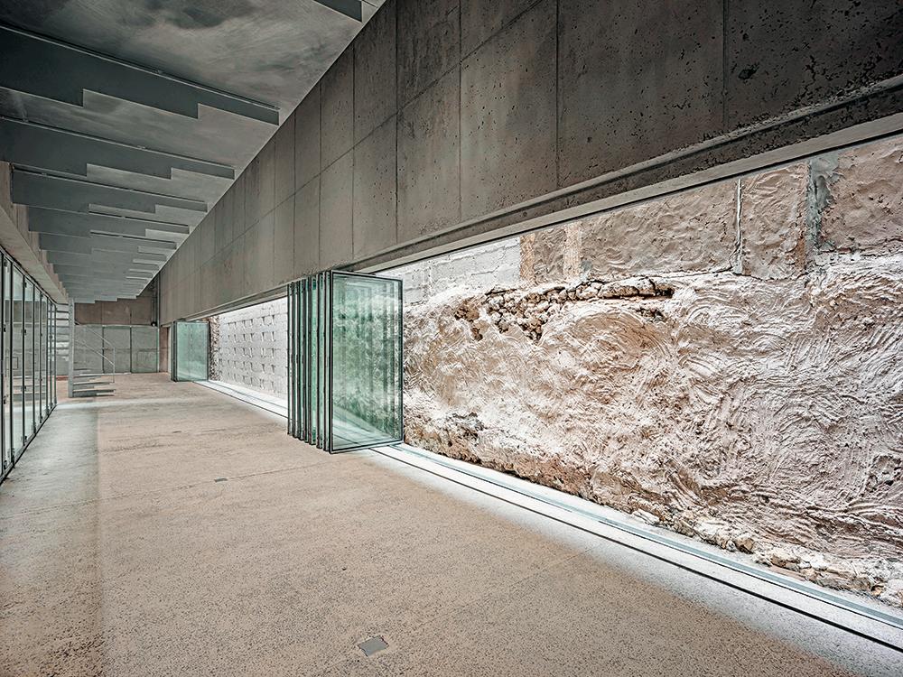 Behind the strip of glazed elements, which can be slid open over their full 26-metre length, the external walls of the adjoining building are an exhibit in their own right.