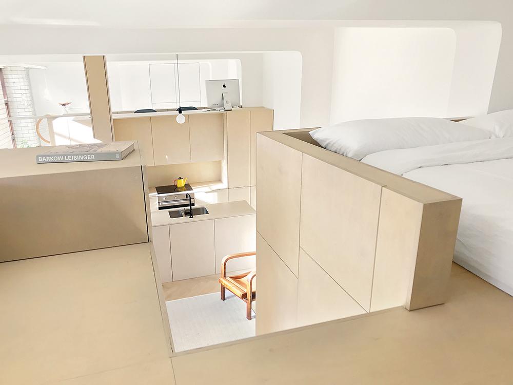 Die Einbauten aus Birkensperrholz vereinen mehrere Funktionen: Der Garderobenschrank ist zugleich Sitzbank, über dem Bad liegt eine Galerie mit Gästebett.