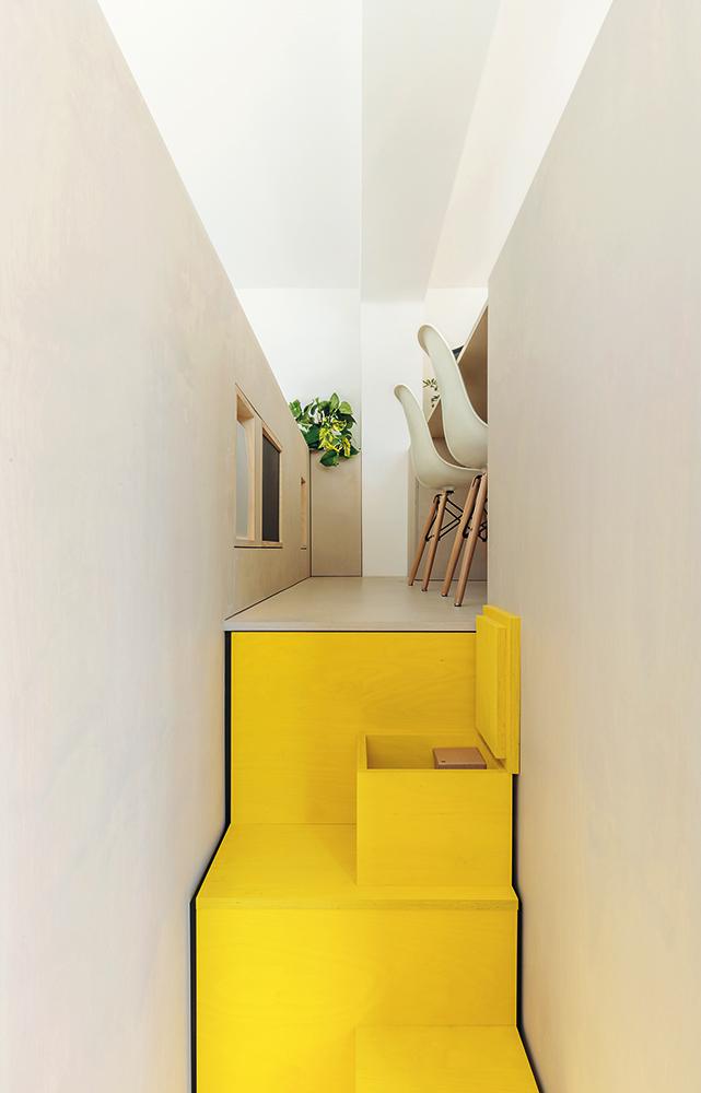 Die Architekten nutzen die Dicke der Holzwände und den Hohlraum unter den Treppenstufen, um Stauraum in Form von Regalen oder Kästen zu schaffen.