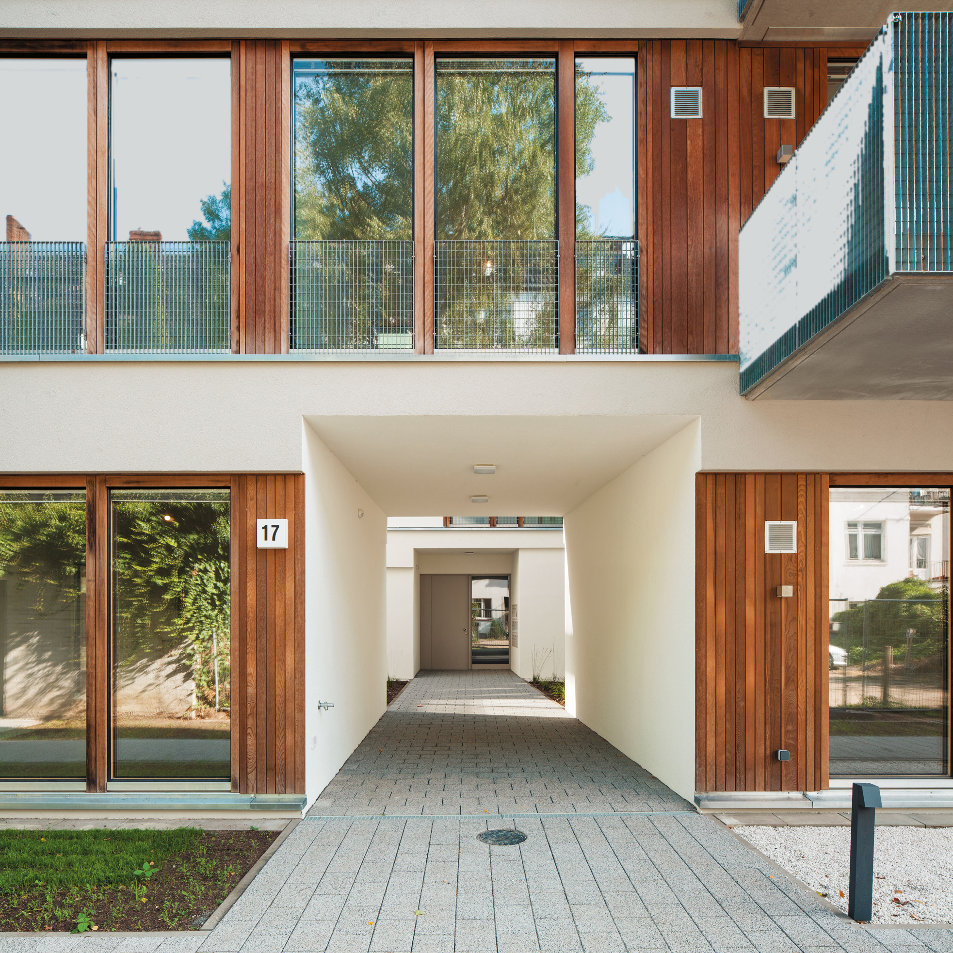 An der großzügig verglasten Nordfassade liegen die Wohn- und Schlafzimmer der Wohnungen, die Hauseingänge befinden sich dagegen zurückgesetzt in den Atrienhöfen.