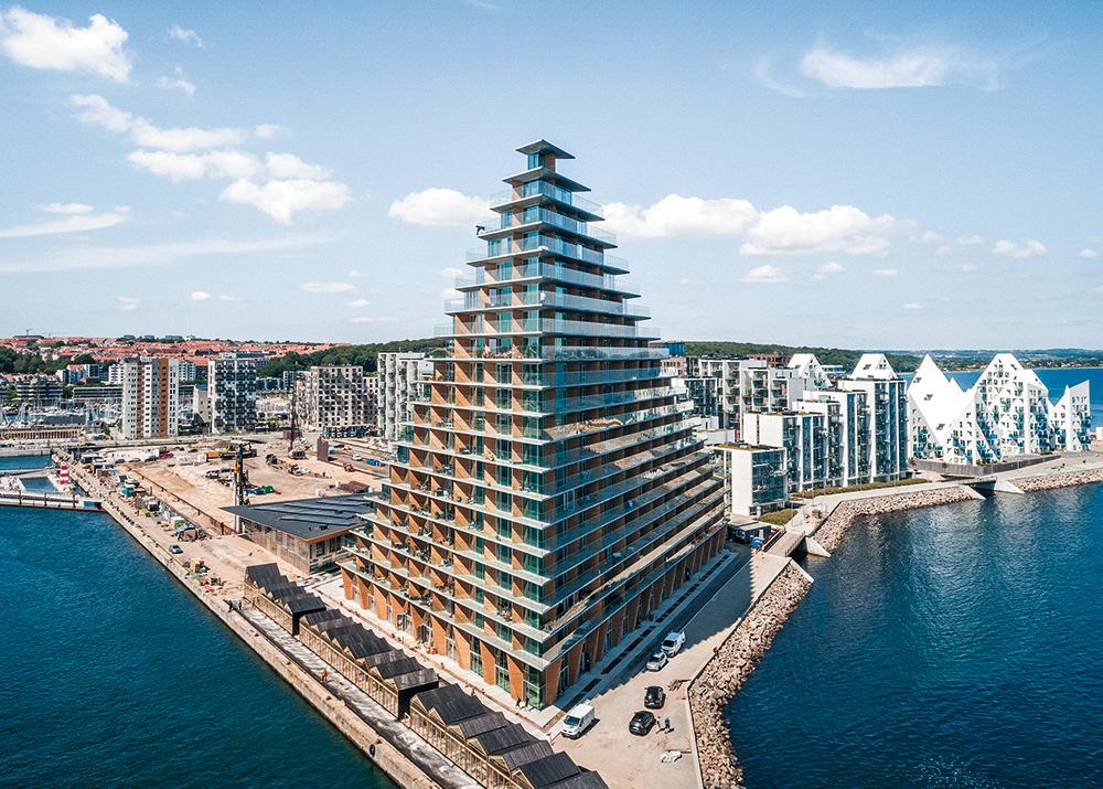 Auf drei Seiten ist die Tiefgarage von Läden umgeben. Entlang der Nordostfassade kragen die Balkone der Erdgeschosswohnungen über das Wasser.