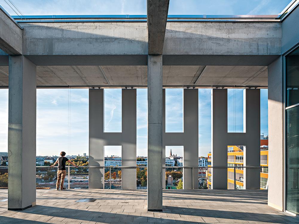 Die Münchner Gehwegplatten auf der Dachterrasse und den Balkonen verdeutlichen deren Funktion als öffentliches Erschließungselement. Ein Pool im dritten Obergeschoss ist die Attraktion des dreigeschossigen Fitness Studios.
