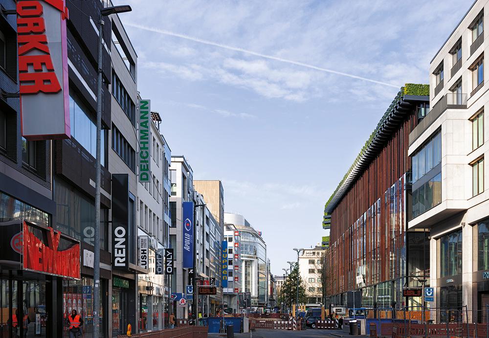 Zum Gustav-Gründgens-Platz legt sich die Bepflanzung über das Gebäude wie eine grüne Kapuze. Die Schaufensterseiten zu den Einkaufs straßen im Süden und Osten sind gebäude hoch verglast.