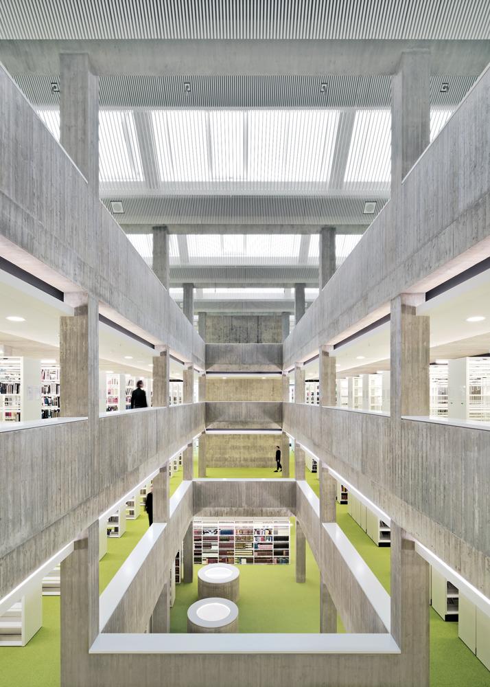 Die weißen Innenausbauten lassen die Innenräume leuchten, obwohl hier auf Weißbeton verzichtet wurde. Die zentrale Halle verbindet alle vier Ebenen des Lesesaals.