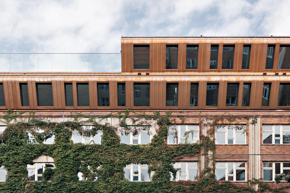 Die Dachaufbauten auf dem Bestandsgebäude sind in Holzmassivbauweise errichtet. Eine Konstruktion aus Furnierschichtholz bildet das Dach auf dem neuen Anbau aus Stahlbeton.