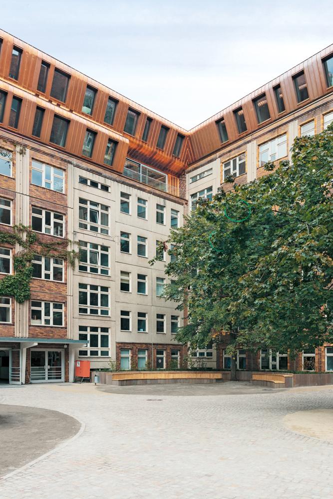 Die Dachaufbauten auf dem Bestandsgebäude sind in Holzmassivbauweise errichtet. Eine Konstruktion aus Furnierschichtholz bildet das Dach auf dem neuen Anbau aus Stahlbeton.