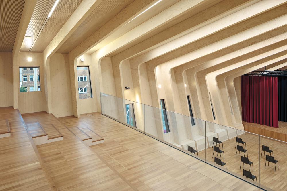Im fast 10 m hohen Dachgeschoss des Anbaus befindet sich das Auditorium. Die Konstruktion aus Furnierschichtholz ist sichtbar geblieben.