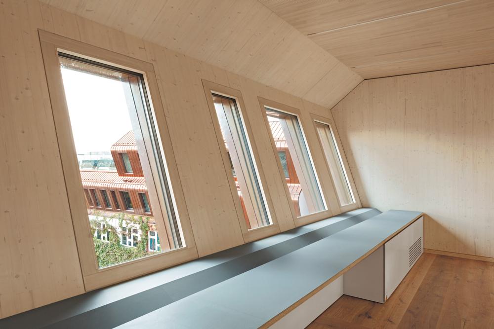 Im fast 10 m hohen Dachgeschoss des Anbaus befindet sich das Auditorium. Die Konstruktion aus Furnierschichtholz ist sichtbar geblieben.