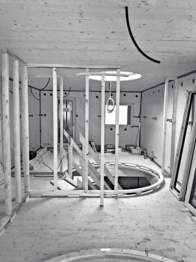 Die runde Trennwand um die Treppe besteht aus furnierten, rückseitig geschlitzten MDF-Platten, die auf einer Holzunterkonstruktion montiert sind.