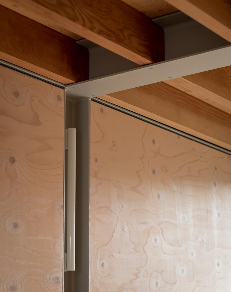 Die Wandflächen der Treppe und des Schlafzimmers sind mit Gipskarton bekleidet, der das Tageslicht reflektiert. In den Wohnräumen dominieren Ziegel und Holz.