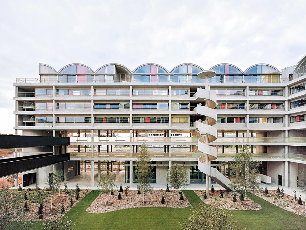 Das Wohnheim nimmt drei Seiten eines noch unfertigen Baublocks ein. Die offenen Parkebenen lassen sich später noch für andere Nutzungen ausbauen.