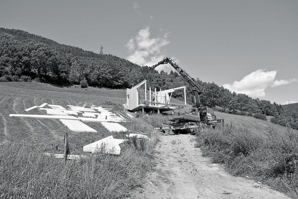 Um Eingriffe in das Erdreich zu minimieren, steht der Holzbau auf einem Stahlrost mit Punktfundamenten. Ein Autokran hob die vorgefertigten Holzelemente an Ort und Stelle.