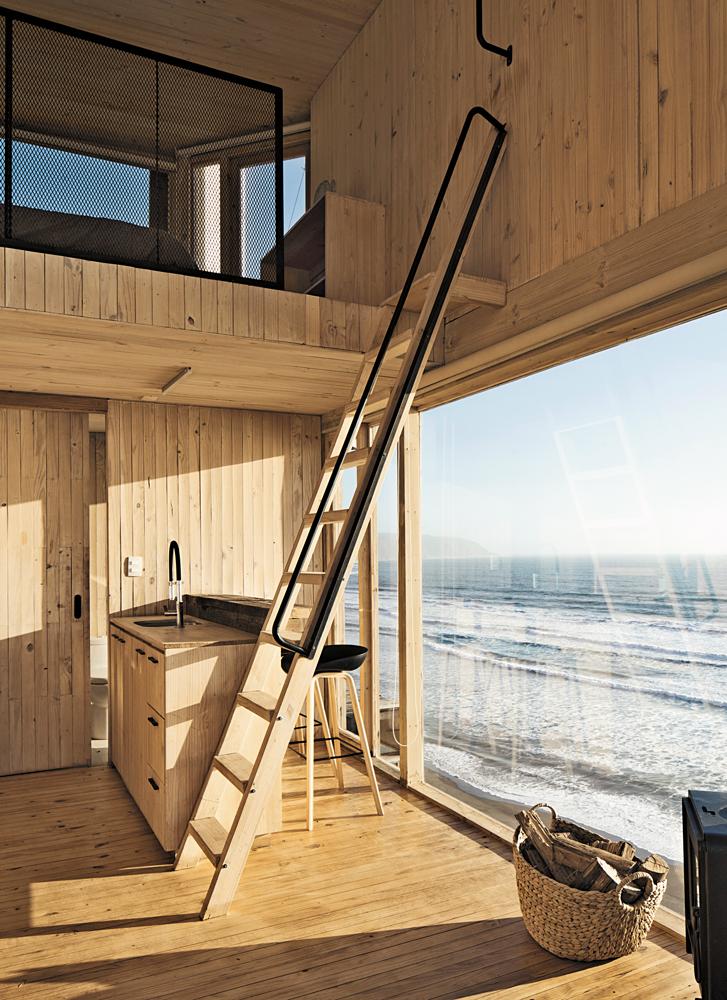 Mit geschosshohen Fenstern öffnen sich die Wohnräume der beiden Häuser zum Meer. Die oberen Schlafebenen sind über steile, leiterartige Treppen erreichbar.