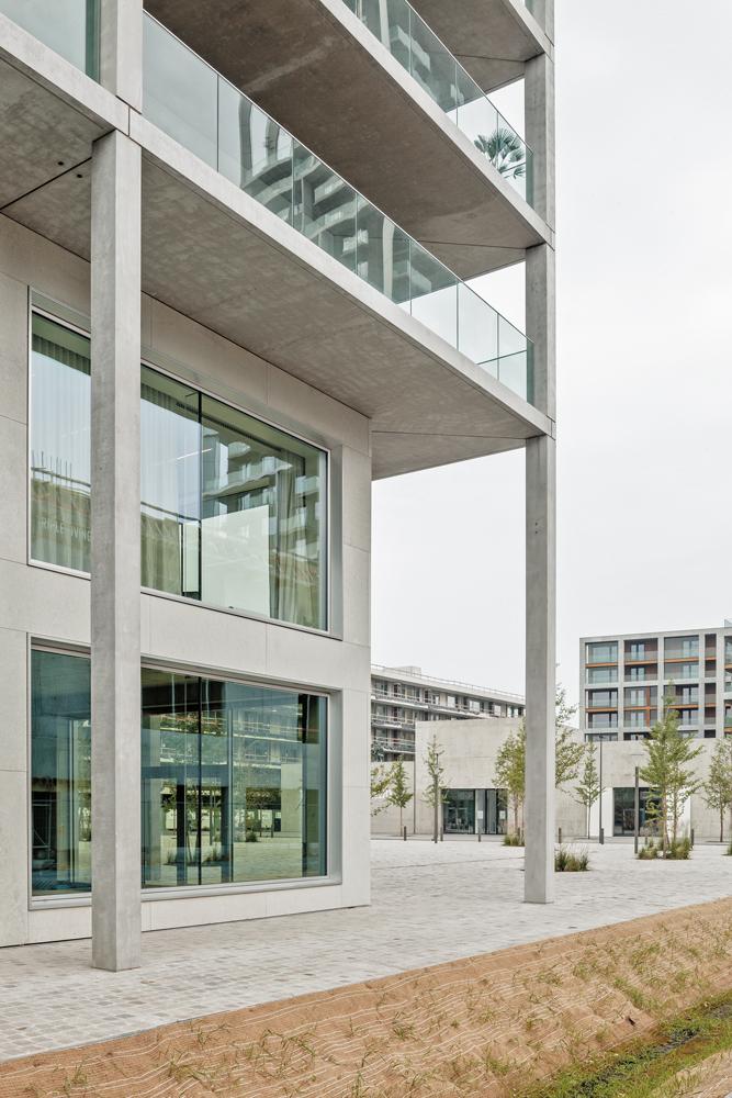 Große Fenster, breite Kalksteinpaneele und schlanke, doppelgeschossige Sichtbetonstützen mit einem Achsabstand von 7,35 m verleihen dem Gebäude zugleich Leichtigkeit und Monumentalität.