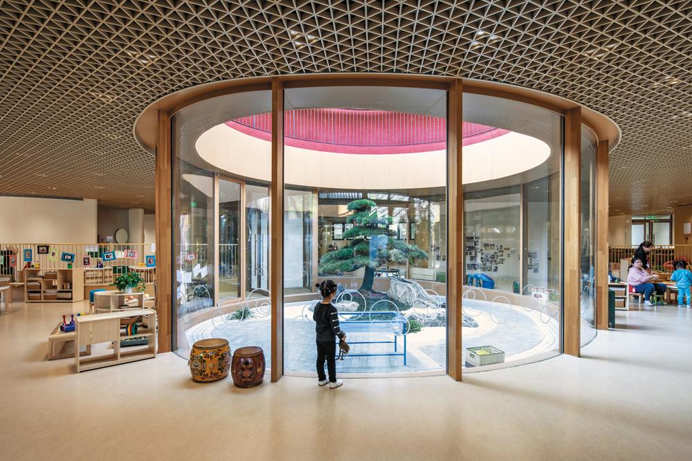 Mehrere Innenhöfe streuen Tageslicht in die durchgängig offen gehaltenen Flächen des altersübergreifenden Kindergartens.