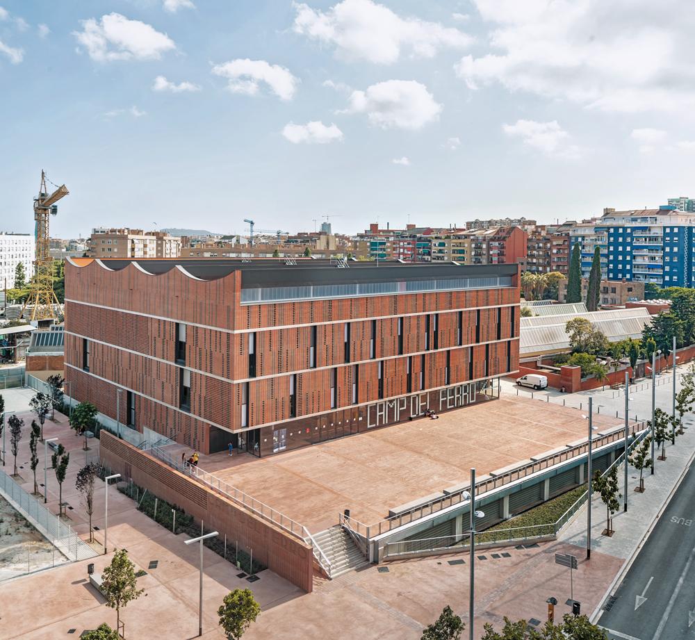Für die Fassade eines neuen Sportzentrums in Barcelona entwickelten die Architekten gitterförmige Sonderziegel, die die Innenräume mit Tageslicht versorgen.