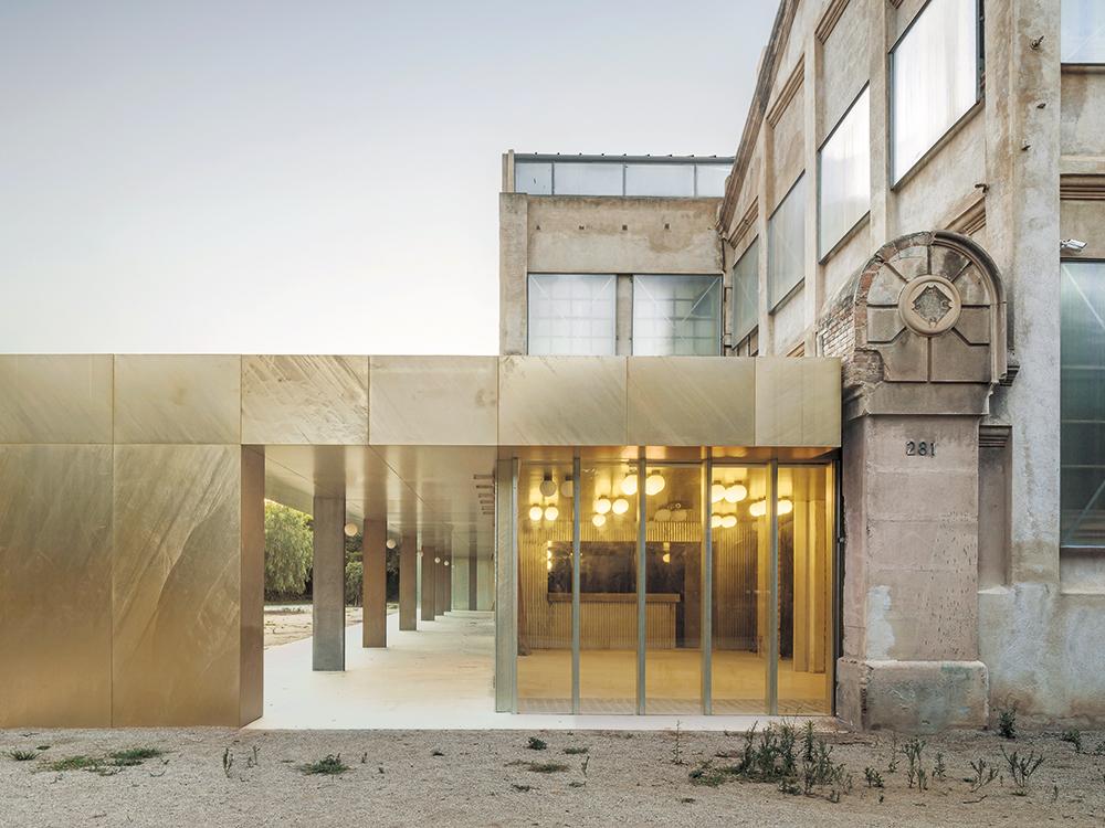 Der neue Haupteingang erweitert das Bestandsgebäude der früheren Fabrik. Seine schimmernden Oberflächen setzen ein Zeichen für das postindustrielle Zeitalter.