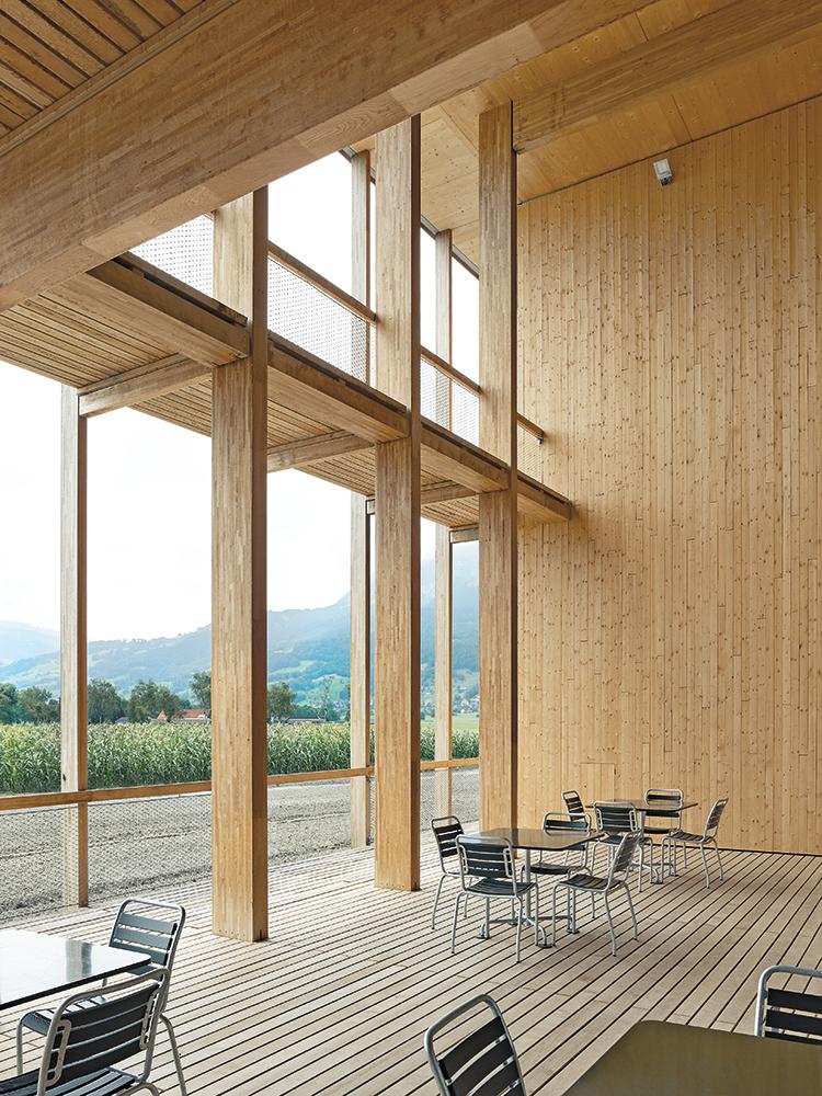 Ein Gebäudeeinschnitt auf der Südseite schafft Raum für eine überdachte, teilweise zweigeschossige Terrasse mit großzügigen Ausblicken in die freie Landschaft.