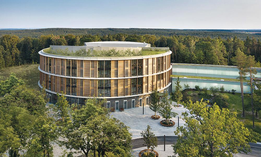 Der Neubau der Waldkliniken Eisenberg ist als Zylinder mit reduziertem ökologischen Fußabdruck konzipiert. Alle Patienten blicken von ihrem Zimmer ins Grüne.
