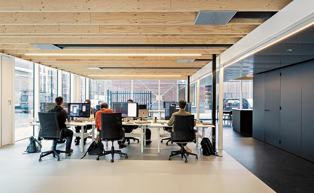 Das offene Bürokonzept bietet flexible Arbeitsflächen. Zwischen den Rippen der Massivholzdecken sind die haustechnischen Leitungen integriert.