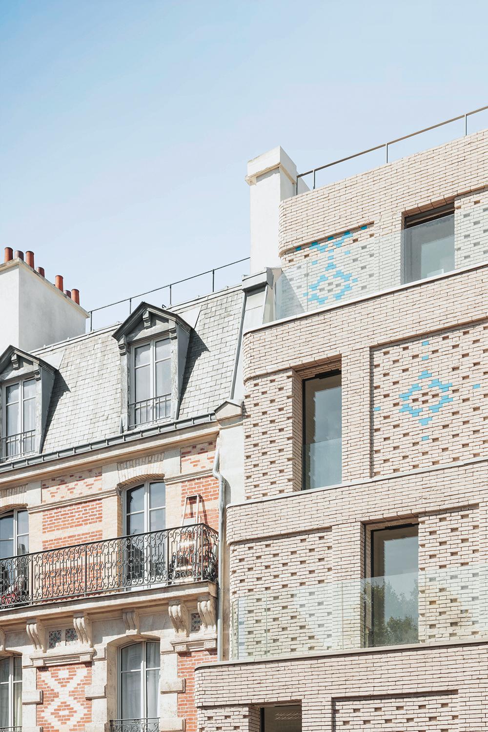 Hohlfugen und blau glasierte Ziegel interpretieren den Fassadenschmuck des Nachbargebäudes zeitgemäß. Ab der fünften Etage ist das Wohngebäude treppenartig zurückversetzt und den Wohnungen ist ein Balkon vorgelagert.