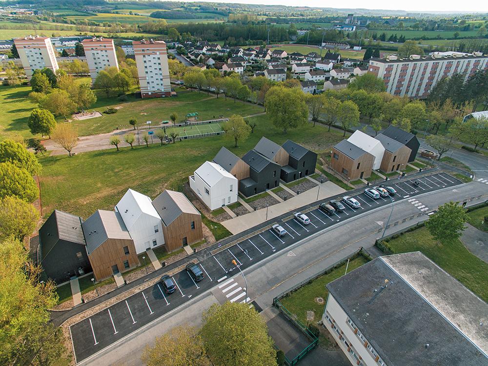 Das Grundstück der 13 Häuser schließt direkt an einen Landschaftspark an. Sie erinnern an Kinderzeichnungen, die aus der benachbarten Schule stammen könnten.